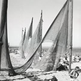 Plażowicze obok sieci rybackich